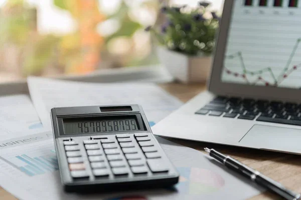 Calculadora y laptop en un escritorio debido a que su dueño está buscando cómo realizar una auditoría interna